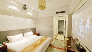 A hotel room with a bed, a television, and a projector screen. - Anqing Yingdeli Hotel (Anqing)