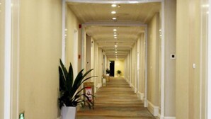 A long, narrow hallway with white walls and a wooden floor, leading to a dark room at the end. - Anqing Yingdeli Hotel (Anqing)
