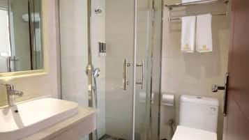 A modern bathroom with a glass shower enclosure, a white sink, and a toilet.