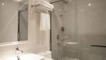 A modern bathroom with a glass-enclosed shower, a white sink, and a large mirror.