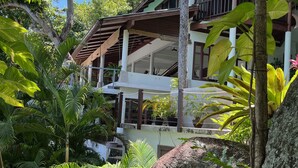 A multi-story building with a wooden balcony, surrounded by lush tropical vegetation. - Koh Samui Villa, Beautiful Pool and Wide Sweeping Sea Views over the Islands  (NAMUANG)