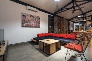 A modern living room with a sectional sofa, a wooden coffee table, and a wicker chair.