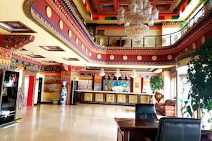 Um hall amplo com balcão de recepção, área de estar e teto decorativo.