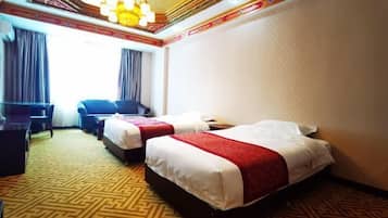 Quarto de hotel com duas camas, uma mesa e uma cadeira.