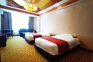 Une chambre d’hôtel avec deux lits, un bureau et une chaise.