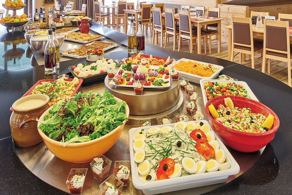 A buffet setup with various food items and condiments.