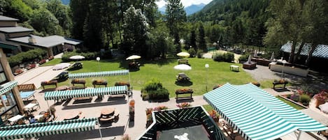 A patio area with outdoor seating, a stage, and a view of mountains.