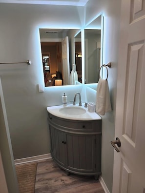 Une salle de bain avec un meuble-lavabo, un évier et un miroir.