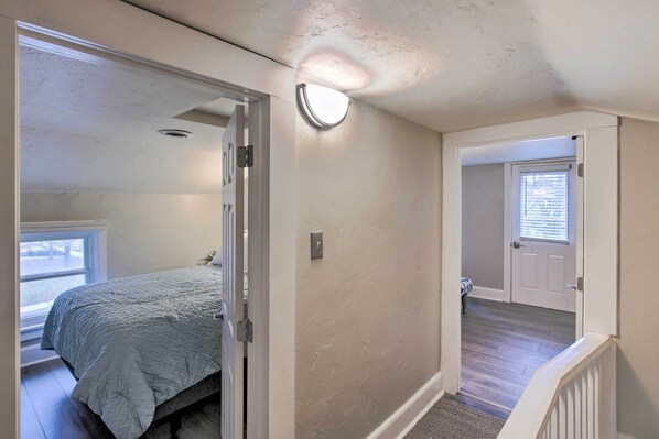 A bedroom with a bed, a door leading to another room, and a window. - Coastal Comfort & Golfers' Paradise in Sheboygan! (Sheboygan)