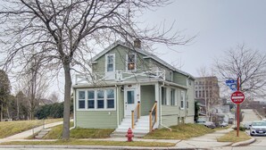 A two-story house with a front porch and a red fire hydrant in front. - Coastal Comfort & Golfers' Paradise in Sheboygan! (Sheboygan)