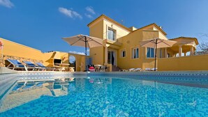 A poolside area with a clear blue pool, lounge chairs, and a yellow building with a balcony. - Wonderful private villa for 10 people with private pool, A/C, WIFI, TV, terrace and pets allowed (Benissa)