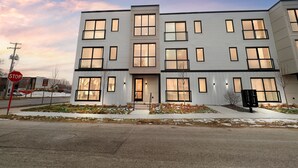 A modern multi-story building with large windows and a flat roof. - The Bish: Traverse City Fall Getaway | Wine Country & Downtown | Sleeps 2 (Traverse City)
