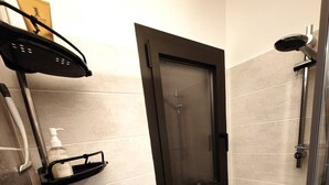 A modern bathroom with a shower, a toilet, and a towel rack.