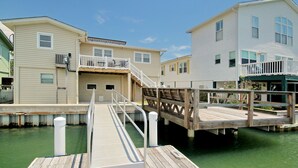 A wooden dock leading to a marina with houses on stilts. - Amazing view and we love dogs (North Myrtle Beach)