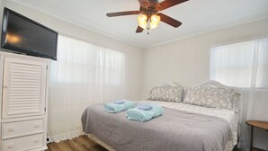 A bedroom with a bed, a dresser, a ceiling fan, and a TV. - Amazing view and we love dogs (North Myrtle Beach)