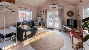 A cozy living room with a sofa, TV, and a large window.