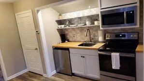 A compact kitchen with a microwave, oven, and dishwasher.
