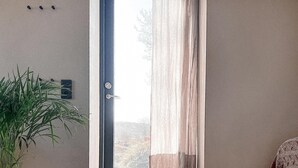 Une pièce dont la porte donne sur un paysage enneigé.