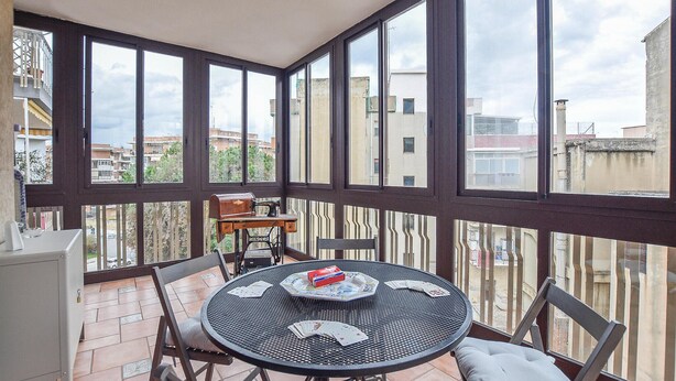 A balcony with a round table set for dining, chairs, and a sewing machine. - 1 bedroom beautiful apartment in Siracusa (Siracusa)