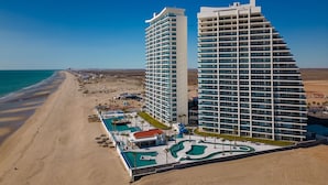 A modern hotel with a pool area and beach access.