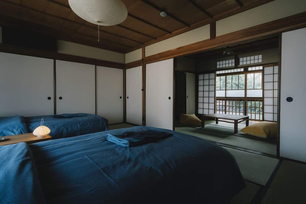 Um quarto japonês tradicional com tatames, uma mesa baixa e portas deslizantes.