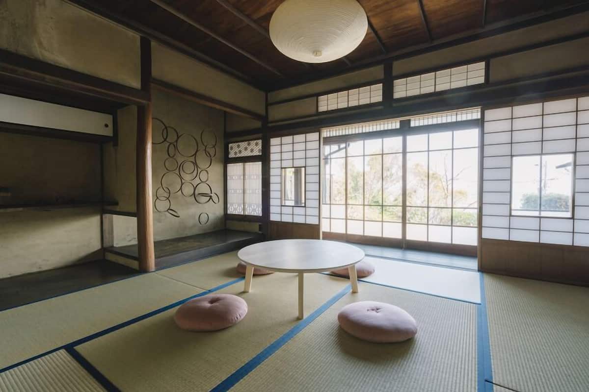 Um quarto tradicional em estilo tatami, com esteiras de tatami, uma mesa redonda e almofadas.