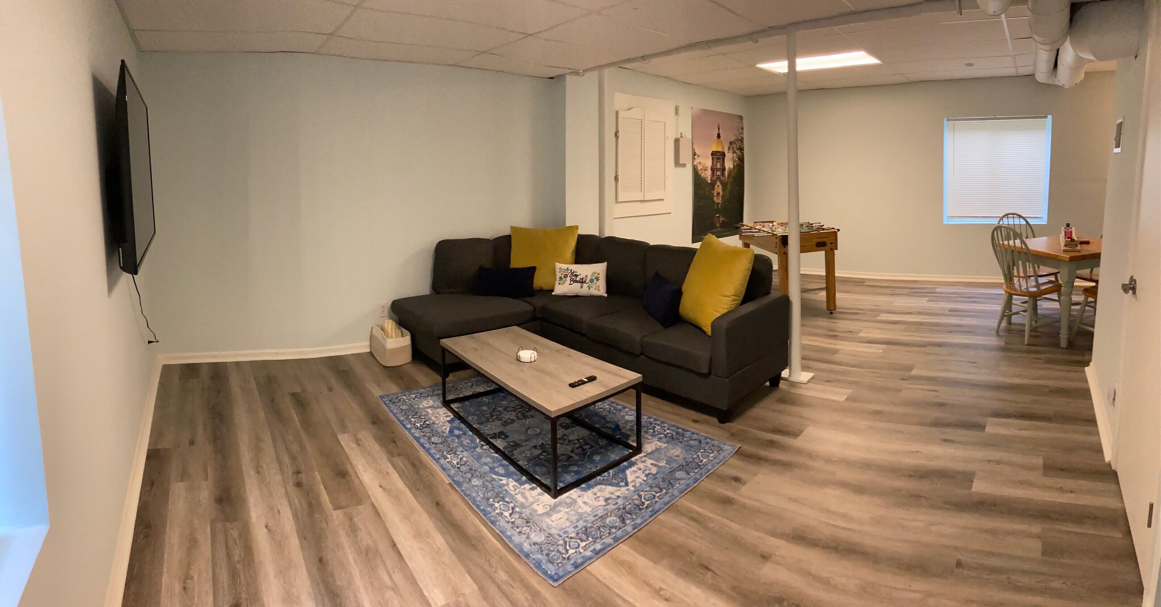 Una sala de estar con un sofá, una mesa de centro y un comedor con una mesa y sillas.