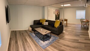 Uma sala de estar com sofá, mesa de centro e um espaço de jantar com mesa e cadeiras.