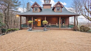 A wooden house with a porch, two potted plants, and a gravel driveway. - Family Cabin With Mountain Views (Boone)
