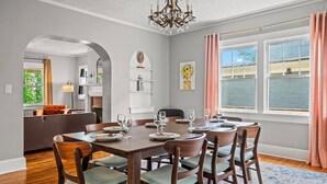 Comedor con una mesa de madera dispuesta para seis personas, rodeado de sillas con asientos acolchados.
