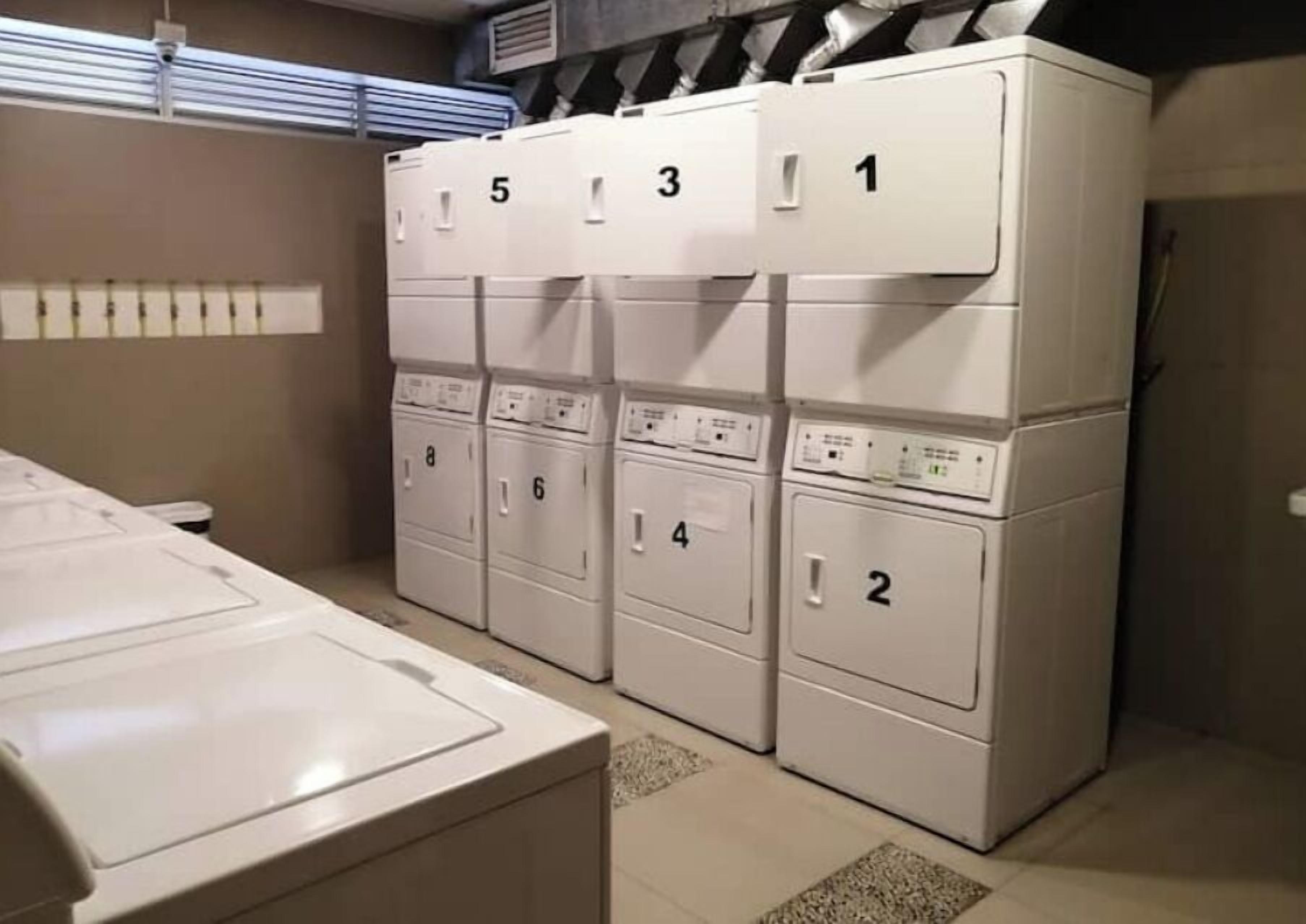 A laundry area with stacked washers and dryers, numbered from 1 to 8.