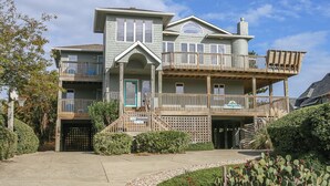A two-story house with a balcony, a garage, and a well-maintained garden. - PLEASURE ISLAND - 5 BR Home in Schooner Ridge w/Access to Community Pools & Rec Center (Duck)