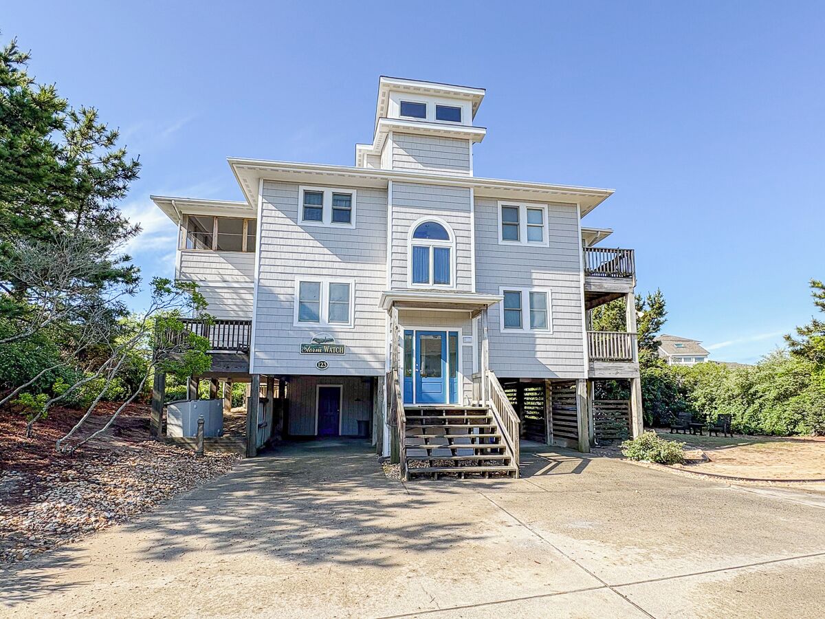 A two-story house with a front porch, a small balcony on the second floor, and a garage.