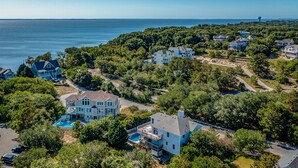 Un quartier résidentiel situé sur la côte, où les maisons sont entourées d’une végétation luxuriante et offrent une vue dégagée sur l’océan.