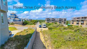 A pathway leading to beach access in a residential area with houses and a van parked on the road. - Driftin South - 5 BR Oceanside Home in Duck - Short Walk to Shops & Restaurants (Duck)