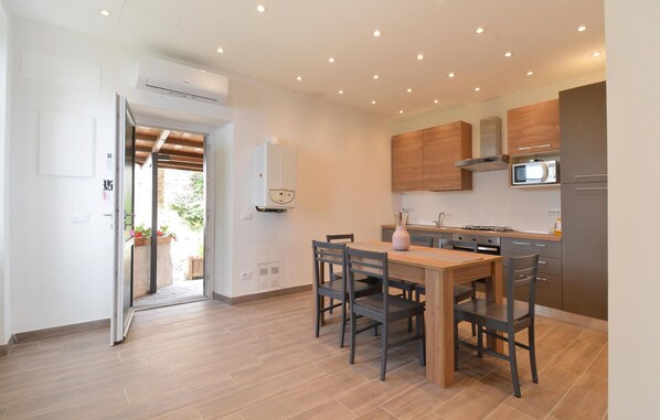 Una cocina moderna con gabinetes de madera, microondas empotrado y estufa a gas.