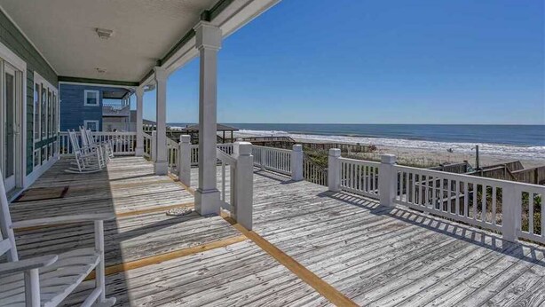 A wooden deck with white railings overlooking a beach. - Hobbs Realty - Enjoy "Miss B Haven", a pet-friendly oceanfront home w/ private pool (Holden Beach)