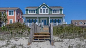 A two-story beach house with a wooden staircase leading to a porch. - Hobbs Realty - Enjoy "Miss B Haven", a pet-friendly oceanfront home w/ private pool (Holden Beach)
