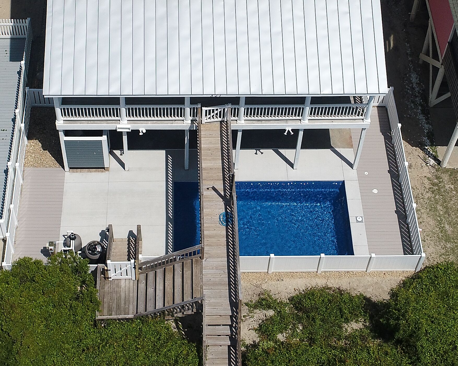 Ein zweistöckiges Gebäude mit Schwimmbad im Erdgeschoss.