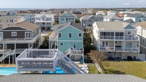 A residential area with houses featuring balconies and a swimming pool. - Legacy - A beautiful 4-bedroom home with a community dock, minutes from the ocean. (Holden Beach)