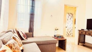 Una sala de estar moderna con un sofá, una mesa de centro y un mueble para la televisión.