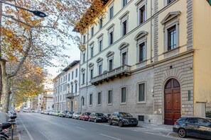 A street lined with parked cars and historic buildings with large windows and a prominent door. - Elica - Sweet Dreams in Florence (Firenze)
