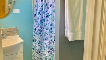 Chuveiro, secador de cabelo, toalhas de banho, shampoo