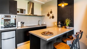 A modern kitchen with a central island, stainless steel appliances, and hanging pots. - Most amazing view of Mexico City. Pool + gym + parking + AC (Ciudad de México)