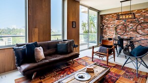 A modern living room with a leather sofa, a dining table, and a large window offering a city view. - Most amazing view of Mexico City. Pool + gym + parking + AC (Ciudad de México)