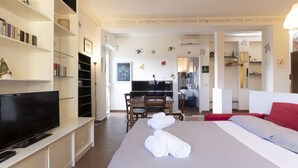 A hotel room with a bed, a TV, a desk, and a dining area. - Casa del Maestro Apartment (Milano)