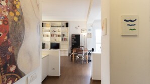 A modern living room with a bookshelf, a dining area, and a TV. - Casa del Maestro Apartment (Milano)