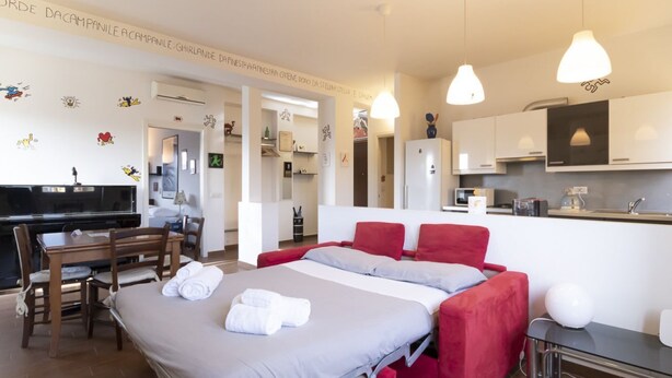 A modern hotel room with a bed, a desk, and a kitchenette. - Casa del Maestro Apartment (Milano)