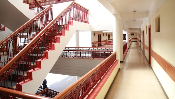 A multi-level interior with a central staircase, multiple floors, and a long corridor. - Hotel Glanton Manor (Ootacamund)