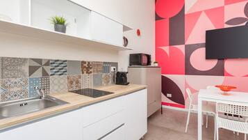 Una cucina moderna con lavello, microonde e zona pranzo con tavolo e sedie.